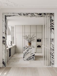 a white and black marbled kitchen with an open door leading into the dining room