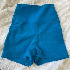 a pair of blue shorts sitting on top of a bed