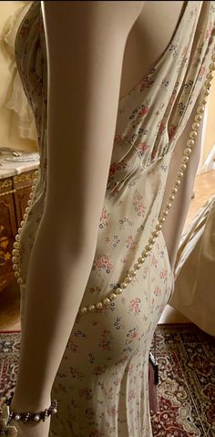 a mannequin wearing a dress with pearls on it