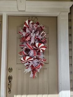 a red and white wreath on the front door