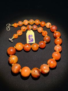 The beautiful orange color carnelian beads necklace from Himalaya Nepal This beads were used in prayer malas and used as jewelry and amulets in ancient times very smooth and shinny surface of this beads because of passage of time and usage of this beads in prayers mala and in necklace The age of this beads are more than 1000 years small size gold color brass beads are used as spacers in the necklace we provide fast and free shipping service to our customers by which can get the items by maximum Orange Agate Oval Beads Jewelry, Orange Agate Oval Beaded Jewelry, Spiritual Carnelian Round Beads Jewelry, Spiritual Carnelian Jewelry With Round Beads, Traditional Orange Gemstone Bead Necklaces, Traditional Orange Gemstone Beads Necklace, Orange Carnelian Round Bead Jewelry, Orange Carnelian Polished Beads Necklace, Traditional Orange Jewelry For Healing