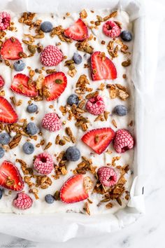 granola with yogurt, strawberries and blueberries in a square pan