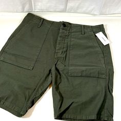 The J Brand Kontact Relaxed Slouch Green Cargo Shorts Are A Versatile And Stylish Choice For Casual Wear. With A Relaxed And Slouchy Fit, These Shorts Provide Both Comfort And A Laid-Back Vibe. The Green Color Adds A Touch Of Modernity, While The Cargo-Style Design Brings A Functional And Utilitarian Feel. Featuring A Flat Front, These Shorts Offer A Clean And Streamlined Look. The 34-Inch Waist Ensures A Comfortable Fit, Making Them Suitable For Various Casual Occasions During Warm Weather. Whe Casual Mid-rise Olive Bottoms, Green Short Cargo Pants With Patch Pockets, Casual Fitted Cargo Shorts, Green Utility Short Pants, Casual Mid-rise Cotton Cargo Shorts, Green Short Utility Pants, Casual Olive Bottoms For Outdoor, Cotton Cargo Style Shorts For Work, Casual Olive Bottoms With Side Pockets