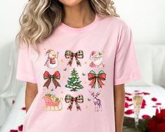 Coquette Christmas Shirt, Pink Bow Christmas Shirt, Pink Santa Shirt, Christmas Shirt, Vintage Christmas Shirt, Retro Christmas Shirt Thank you so much for choosing us! How To Order 1️⃣ Please review all the information provided before placing an order. 2️⃣ Select the shirt type and size using the drop down menu. 3️⃣ Select the color of the shirt using the following drop down menu. 4️⃣ Once all your desired items are in your cart you may complete your order by entering your payment method, desired shipping address and click submit. Shipping Time Shipping will take 1 business days Christmas Holiday Shirt With Graphic Print, Christmas Holiday Graphic Print Shirt, Holiday Cotton Shirt, Cotton Shirt For The Holiday Season, Christmas Festive Shirt With Graphic Print, Festive Christmas Graphic Print Shirt, Pink Cotton Christmas Tops, Christmas Pink Cotton Tops, Christmas Cotton Holiday Shirt