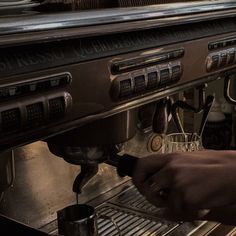 a person is taking something out of an espresso machine