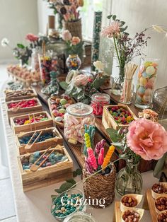 a table filled with lots of candy and candies on top of wooden trays