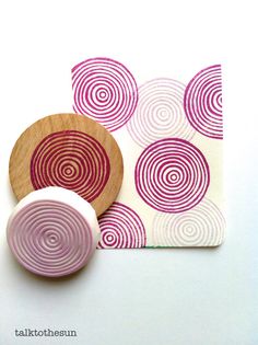 two wooden buttons sitting on top of a piece of paper next to a small coaster