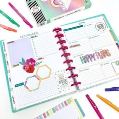 an open planner book with pens and markers