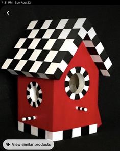 a red birdhouse with black and white checkered roof