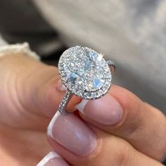 a close up of a person holding a diamond ring