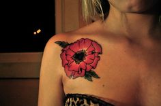 a woman with a flower tattoo on her shoulder