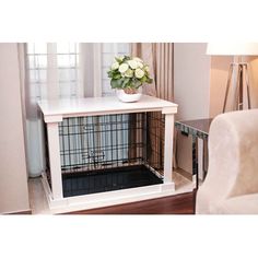 a white dog crate with flowers in it