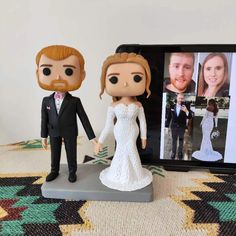 a bride and groom figurine next to a digital photo frame on a rug