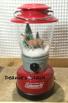 a red and silver snow globe with a deer in it's head on top