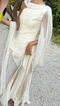 a woman in a white dress posing for the camera