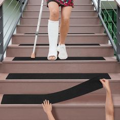 a woman with crutches walking up the stairs while another person holds her leg