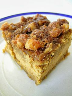 a piece of cake sitting on top of a white plate with nuts and crumbs