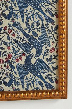 an ornate blue and white wallpaper with birds on it's side in a gold frame