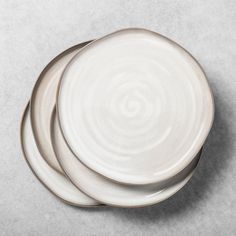 three white plates stacked on top of each other in the shape of a spiral design