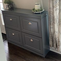 a gray dresser with two plants on top