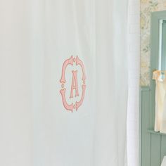 the monogrammed shower curtain in this bathroom is pink and white with an initial on it