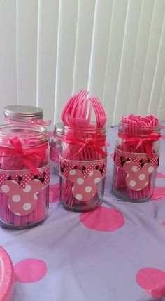 pink and white polka dot cupcakes in mason jars on a purple table cloth