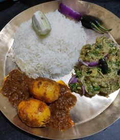 a silver plate topped with rice and different types of food