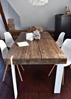 a wooden table with white chairs around it