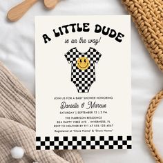 a little dude is on the way baby showering card with wooden spoons next to it