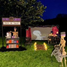 halloween decorations are set up on the lawn for an outdoor movie night at night time