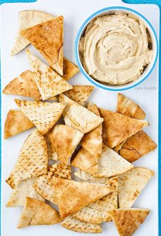 tortilla chips and dip on a plate with a blue towel in the background