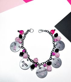 Blackpink bracelets with all the girl's stamped names, I colored their names with black and pink lettering. The bracelet has black and pink beads with cracked glass, pink marbled beads, and black crystals. I used black chain and hearts to represent their light sticks. The middle says Blackpink with a crown stamp. Show off your ultimates with this Blackpink bracelet, it is a must have for all Blinks. Due to the handmade nature of this product, there may be slight variations in charms and beads de Blackpink Bracelet, Black Pink Bracelet, Blackpink Jewelry, Kpop Bedroom, Blackpink Merch, Pandora Black, Pink Pens, Blackpink Blink, Black Chain