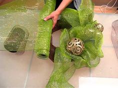 a person is wrapping up some green ribbons with eggs in the center and on top of them