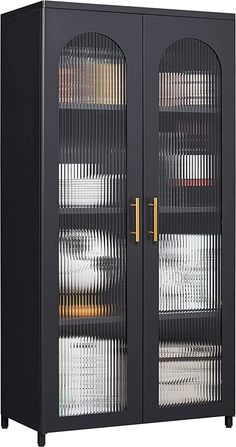 a large black cabinet with glass doors and gold hardware on the top, in front of a white background