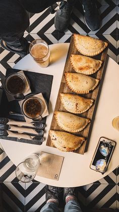 a table topped with lots of food and drinks next to a person's legs