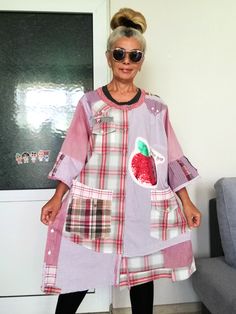 an older woman standing in front of a couch wearing a dress with patches on it