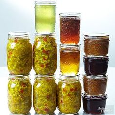 several jars filled with different types of condiments and seasonings on a white surface