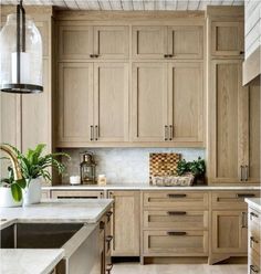 a kitchen filled with lots of wooden cabinets and counter top space next to a sink