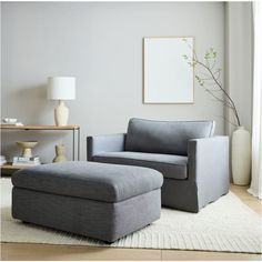 a living room with a gray chair and ottoman