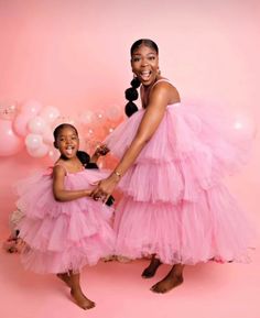 two women in pink dresses standing next to each other