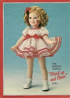 an old fashioned doll with red and white polka dots on it's dress, standing in front of a blue background