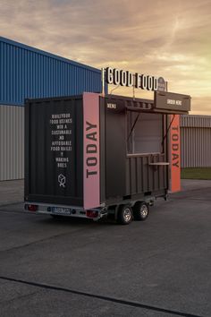 a truck with a trailer attached to it parked in front of a building that says good food