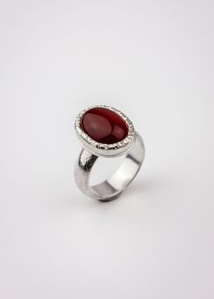 A vibrant red Carnelian is set in a thick bezel with a sparkling hammered texture. Made completely of sterling silver, this modern ring features clean lines and minimalist styling with just enough texturing to focus the mind. The name 'Orka' (Icelandic for 'energy') is given to this ring because, to some, Carnelian symbolizes vibrant energy, life, and creativity. US Size 9 Details:Focal Dimensions: 0.75 in x 0.5 (18 x 14mm)Band: 6 mm wide and slightly domed Modern Red Cabochon Ring, Red Carnelian Ring With Polished Finish, Red Carnelian Rings With Polished Finish, Red Polished Carnelian Rings, Modern Red Gemstone Ring, Modern Carnelian Jewelry With Polished Finish, Modern Red Carnelian Jewelry, Red Carnelian, Carnelian Ring