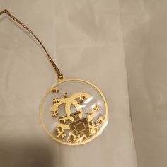 a gold necklace with an image of a woman's face in the center on a white background