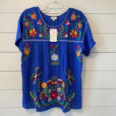 Nwt Boutique Embroidered Top, Large Spring Beach Embroidered Blue Top, Spring Blue Embroidered Top For Beach, Blue Embroidered Top For Spring Beach Occasion, Blue Short Sleeve Embroidered Top For Spring, Blue Embroidered Short Sleeve Top For Spring, Blue Floral Embroidery Top For Vacation, Blue Floral Embroidery Beach Tops, Spring Blue Embroidered Top With Embroidered Hem, Spring Blue Embroidered Top With Hem Detail