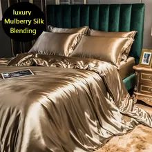 a bed with gold sheets and pillows in a luxurious bedroom, including a green headboard