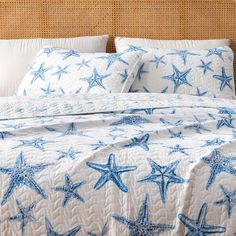 a bed with blue starfish on it and white linens in the comforter