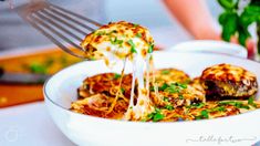 a person is eating some food from a bowl with a fork in it and there are other dishes on the table