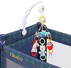 a baby crib with toys hanging from it's sides and the words graco on