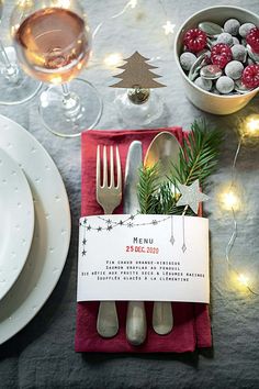 a place setting with silverware and christmas decorations